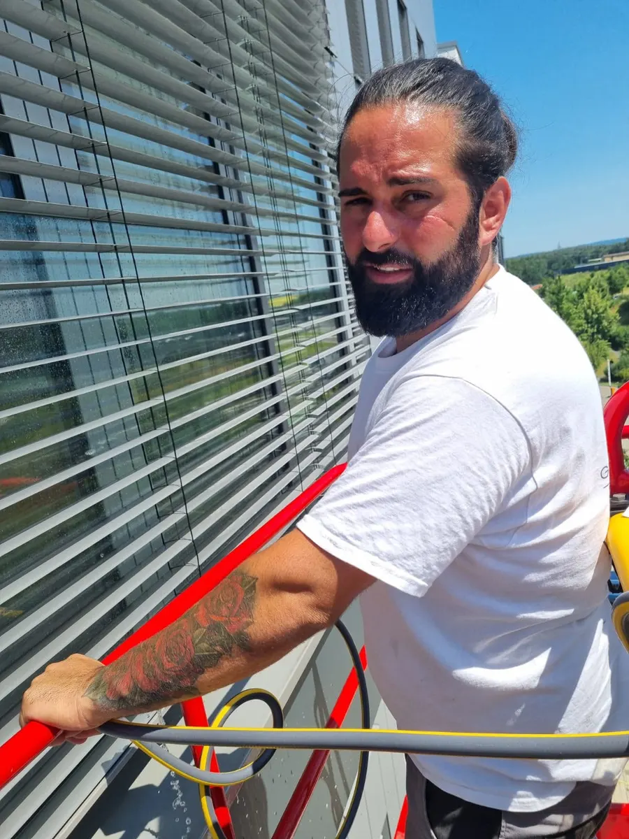 Yalcin Sengül, Inhaber von Glas und Glanz, bei der Reinigung einer Glasfassade